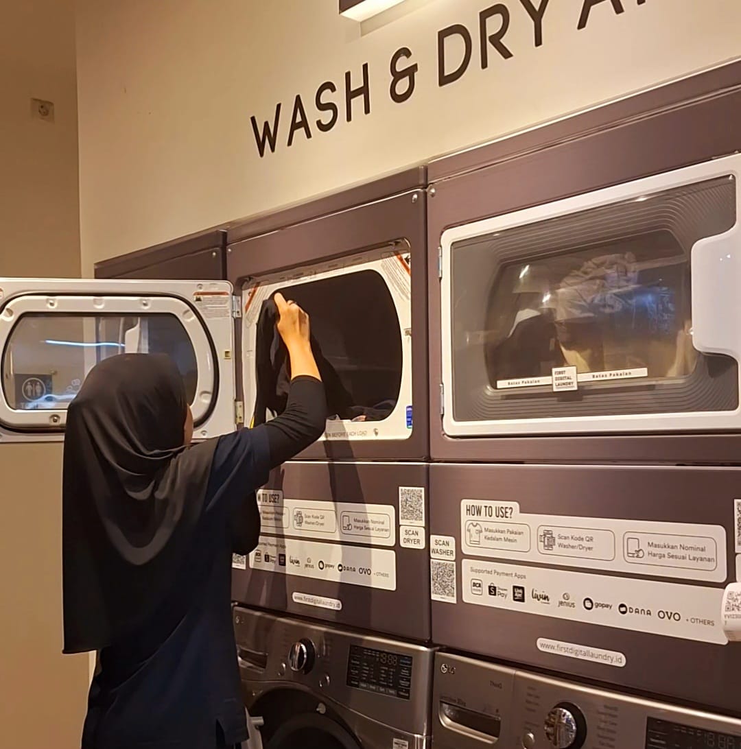 Pelanggan menggunakan mesin laundry self-service